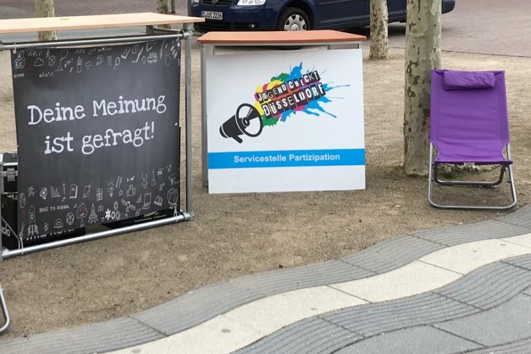 Bild eines Informationsstandes mit dem Logo der Servicestelle