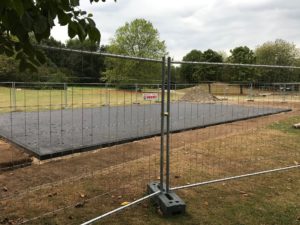 Baustelle mit neuem Sportfeld hinter Bauzaun