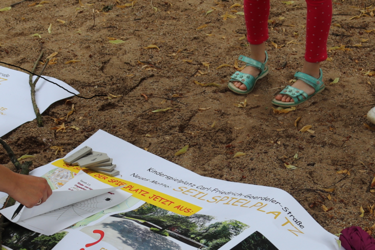 Plakat mit Vorschlägen für Neugestaltung liegt im Sand