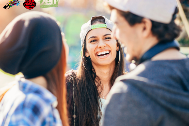 3 junge Menschen stehen beisammen und lachen