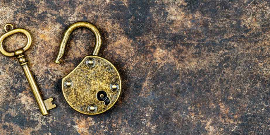 Am rechten Bildrand liegen, vor einem dunklen HIntergrund ein goldener Schlüsel und ein Schloss. Beide sehen alt aus.
