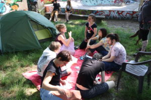Gespräch mit den Fahrradfahrenden Rosa und Charlotte auf der Wiese vor dem AJZ